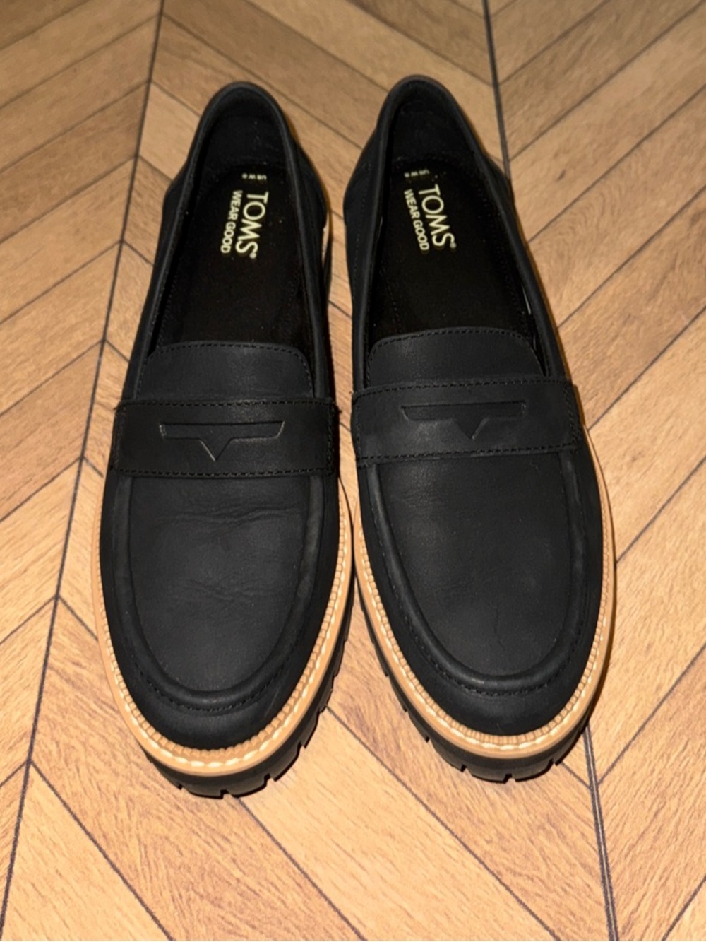 TOMS Womenโs Cara Black Leather Penny Loafers with Tan Outsole Trim